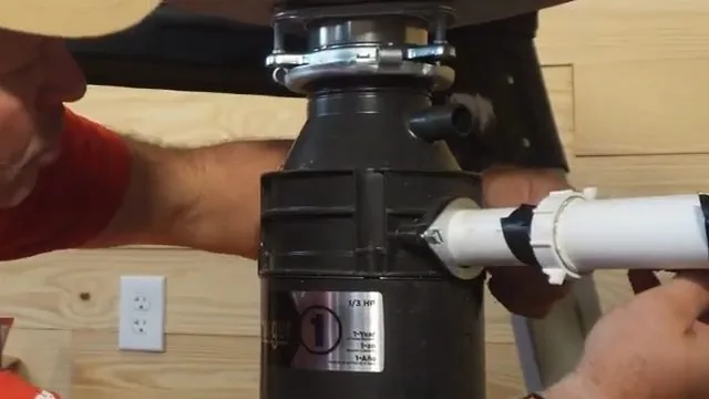 Garbage disposal hanging under a sink with its drain elbow and gasket joint connected